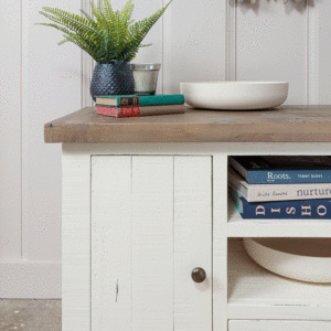 left hand side view of modern farmhouse wooden TV unit with storage- books on storage shelves and fern plant on top surface