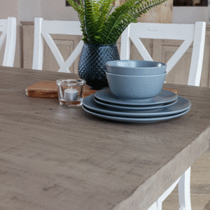 close up of blue crockery set, plant and candle ontop of white and grey dining set tabletop